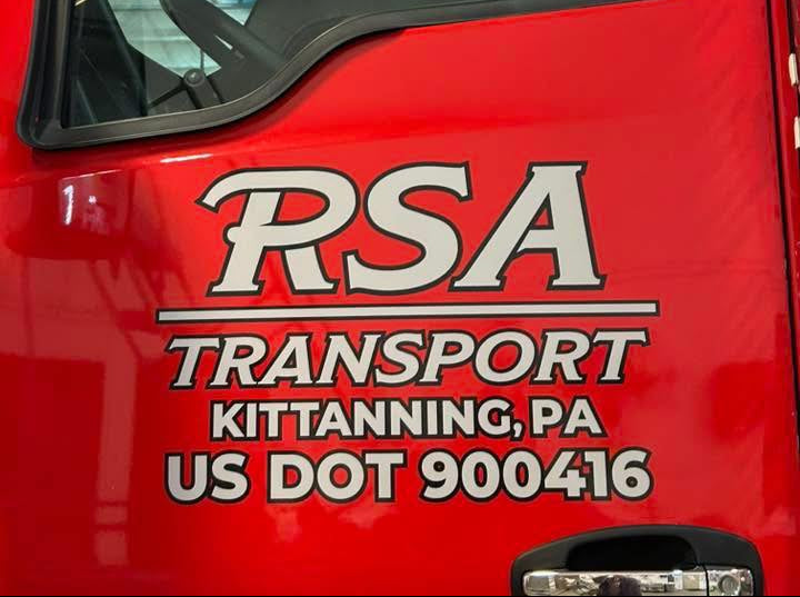 Red truck with RSA Transport logo and contact information on a blurred background